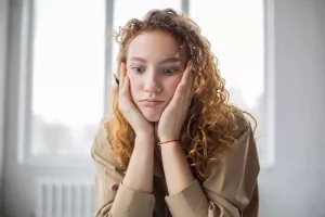 puzzled woman with pen studying in room