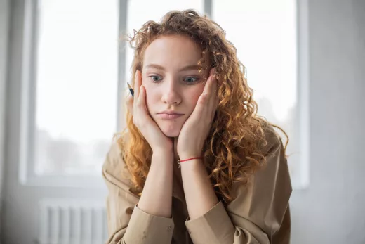puzzled woman with pen studying in room